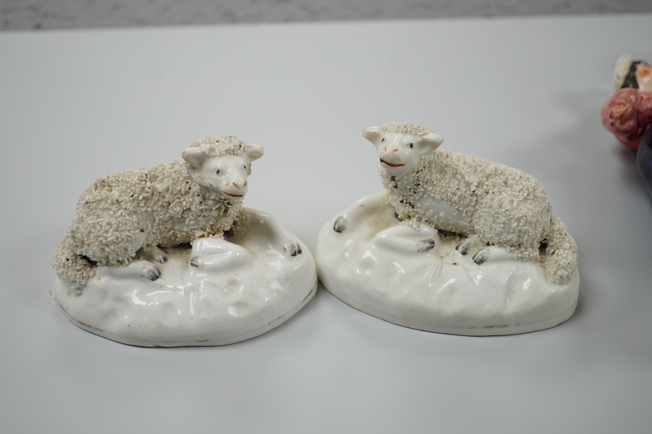 Three small Staffordshire models of recumbent sheep on oval mounted bases, together with a Staffordshire model group of a shepherdess, c.1830-50, (4). Tallest 17.5cm, Provence: Dennis G.Rice collection